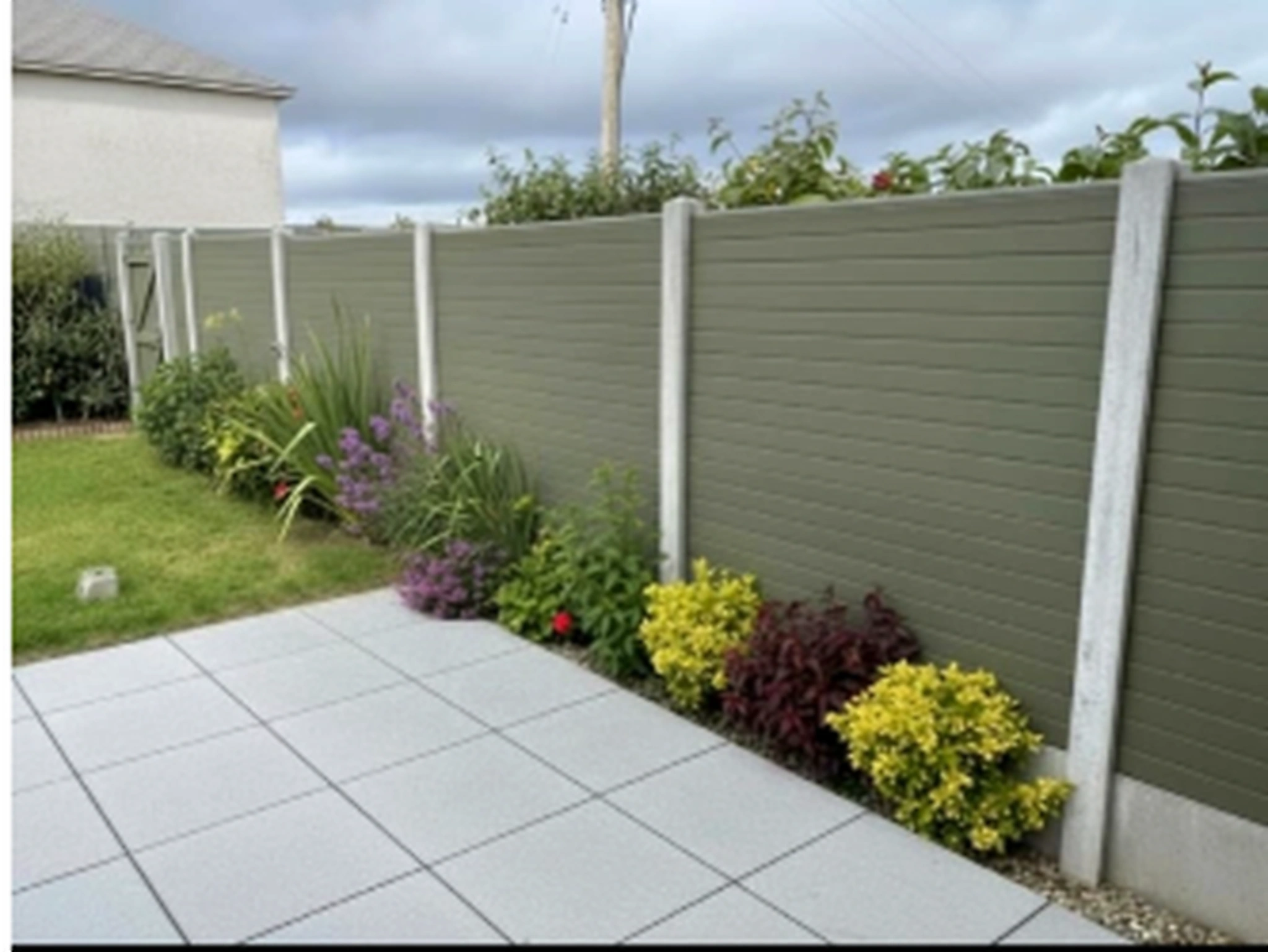 White PVC privacy fencing in a bright landscaped garden